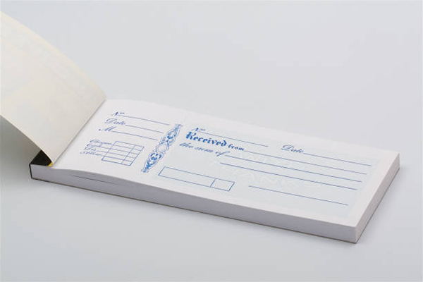 Close up shot of a blank receipt book on a neutral background.